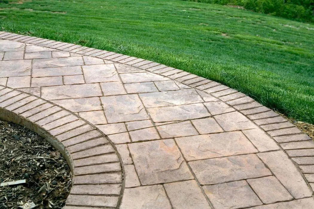 A curved brick pathway with grass